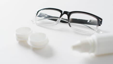 vídeo de gafas, caja de lentes de contacto y solución de lentes sobre fondo blanco con espacio para copiar