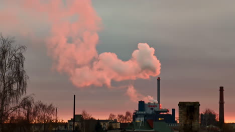 industrial factory plant blowing out steam at sunset with pastel color