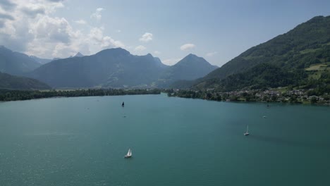 barcos que navegan en el lago en gäsi betlis, walensee glarus, weesen walenstadt, suiza - disparo de avión no tripulado