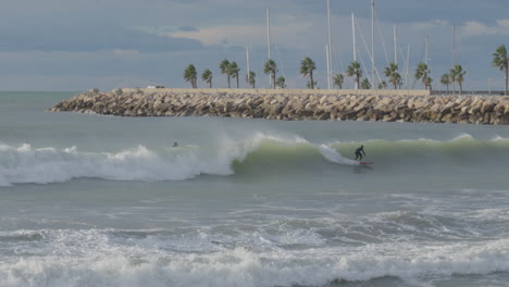 Surfer-Reiten-Auf-Langen-Wellen-In-Der-Nähe-Malerischer-Palmenhaine