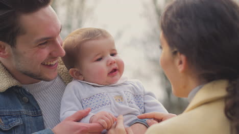 Transgender-Parents-Playing-With-Baby-Son-On-Walk-In-Autumn-Or-Winter-Countryside