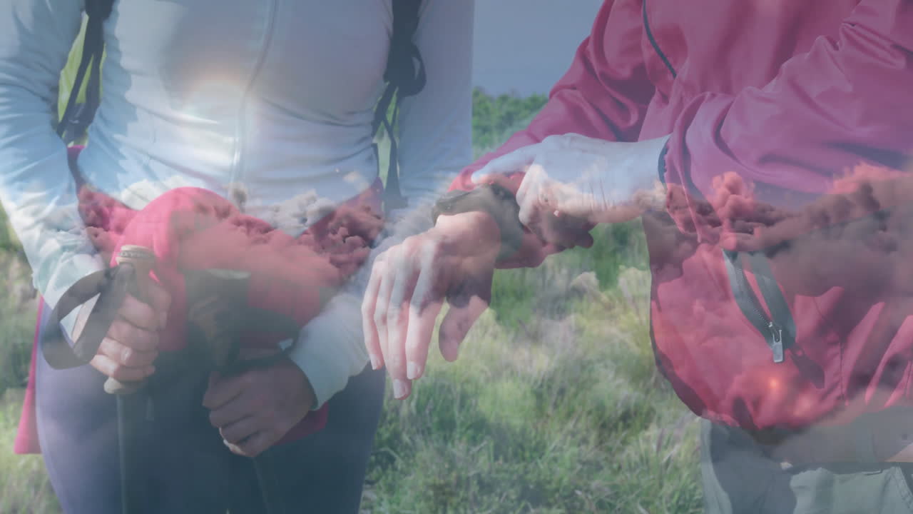 Man and woman hiking grassy hillside, showing animated health metrics chart and weather icons