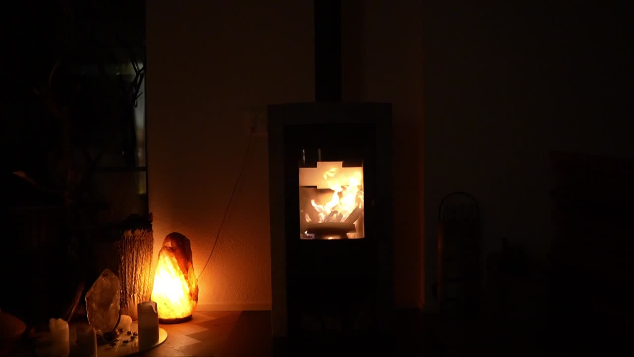 Warm fireplace and glowing salt lamp creating a cozy ambiance in a dimly lit room