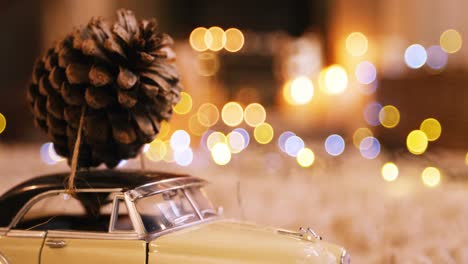 Toy-car-with-pine-cone-on-wooden-table