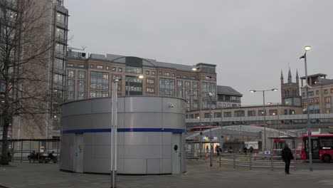 handheld shot of hammersmith bus station with surrounding modern buildings at dusk