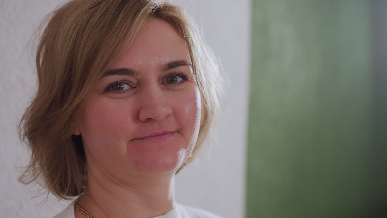 Reflective soul seated on sofa, gazing thoughtfully at therapist in modern therapy room during evening light and cozy atmosphere. Pillows and window revealing dusk outside enhance empathetic exchange