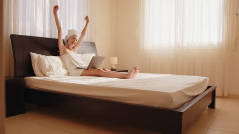 mujer trabajando en la computadora portátil en la cama