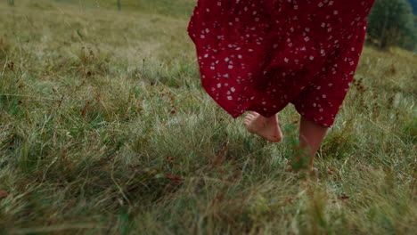 barefoot girl walking grass cloudy day closeup. lady feet making steps on meadow