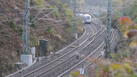 telephoto view of german ice train driving through countryside, static shot