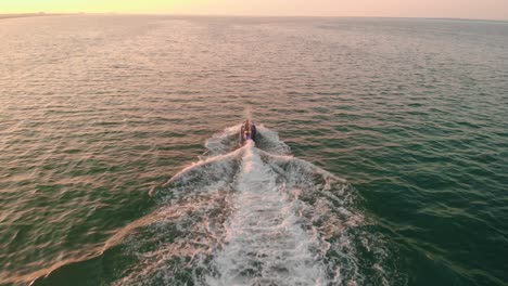 Jet-Ski-rider-and-passenger-riding-off-into-the-sunset,-Abu-Dhabi