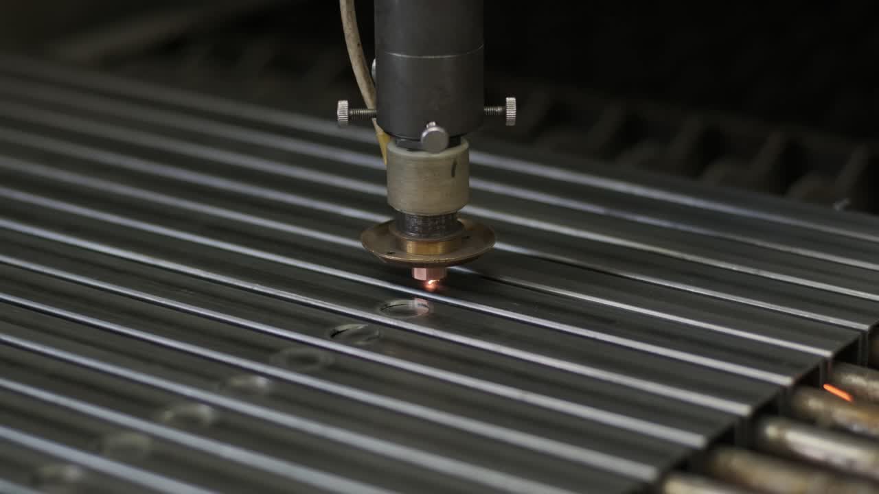 современная промышленная лазерная машина с cnc, технология резки металла. лазерная резка стальных труб на современном заводе. лазер разрезает отверстия в трубе.