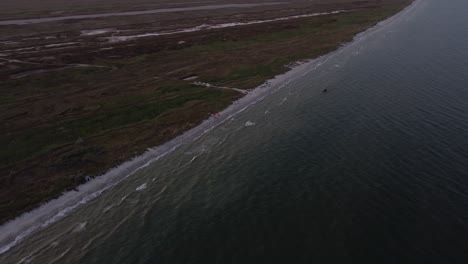 aerial fly by shot of the wild beaches touched by the gentle waves of the black sea at sunset, in vadu, romania, europe