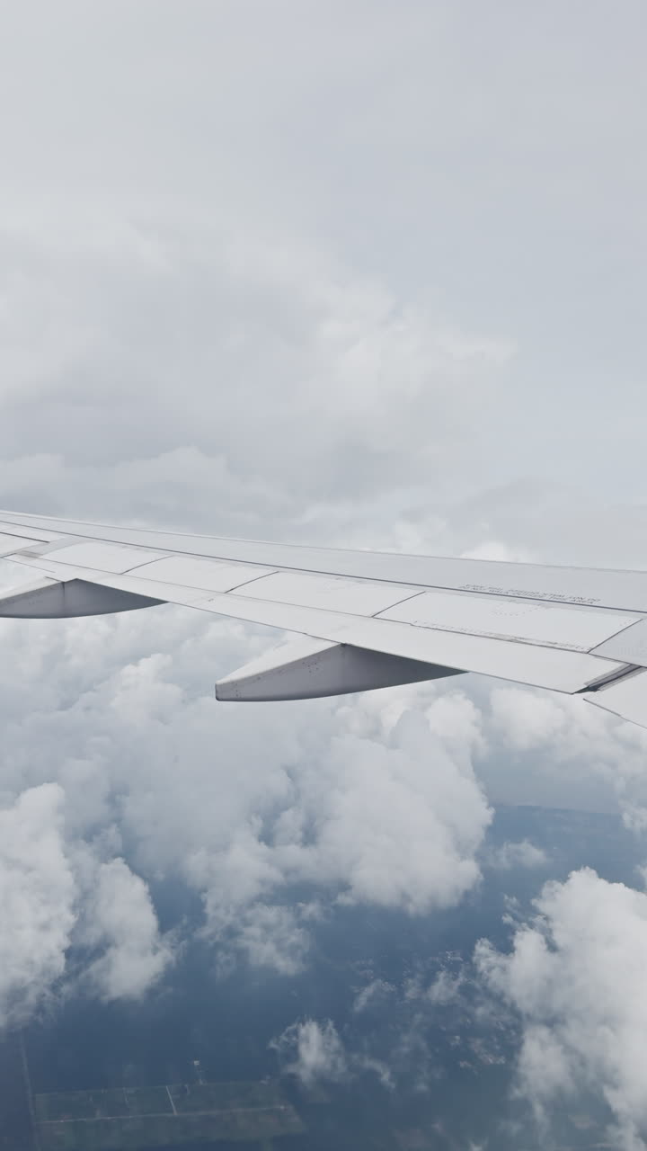 view from a plane window of the sky with the wing shot in vertical