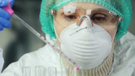 a woman in protective clothing works in a laboratory