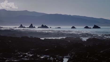 boat passing by at sunrise in island bay in wellington, new-zealand