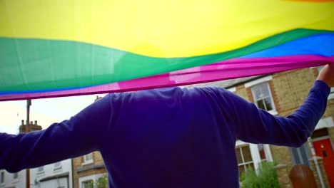 bandera del orgullo ondeando en el viento sobre los hombros