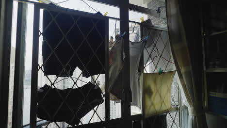 secando ropa en la ventana abierta de un rascacielos en la ciudad de hong kong, de cerca