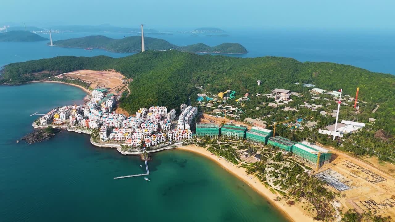 High altitude and wide-angle drone shot of the VinHomes construction site on Phu Quoc Island, Vietnam. A luxury resort designed with Santorini-style architecture.