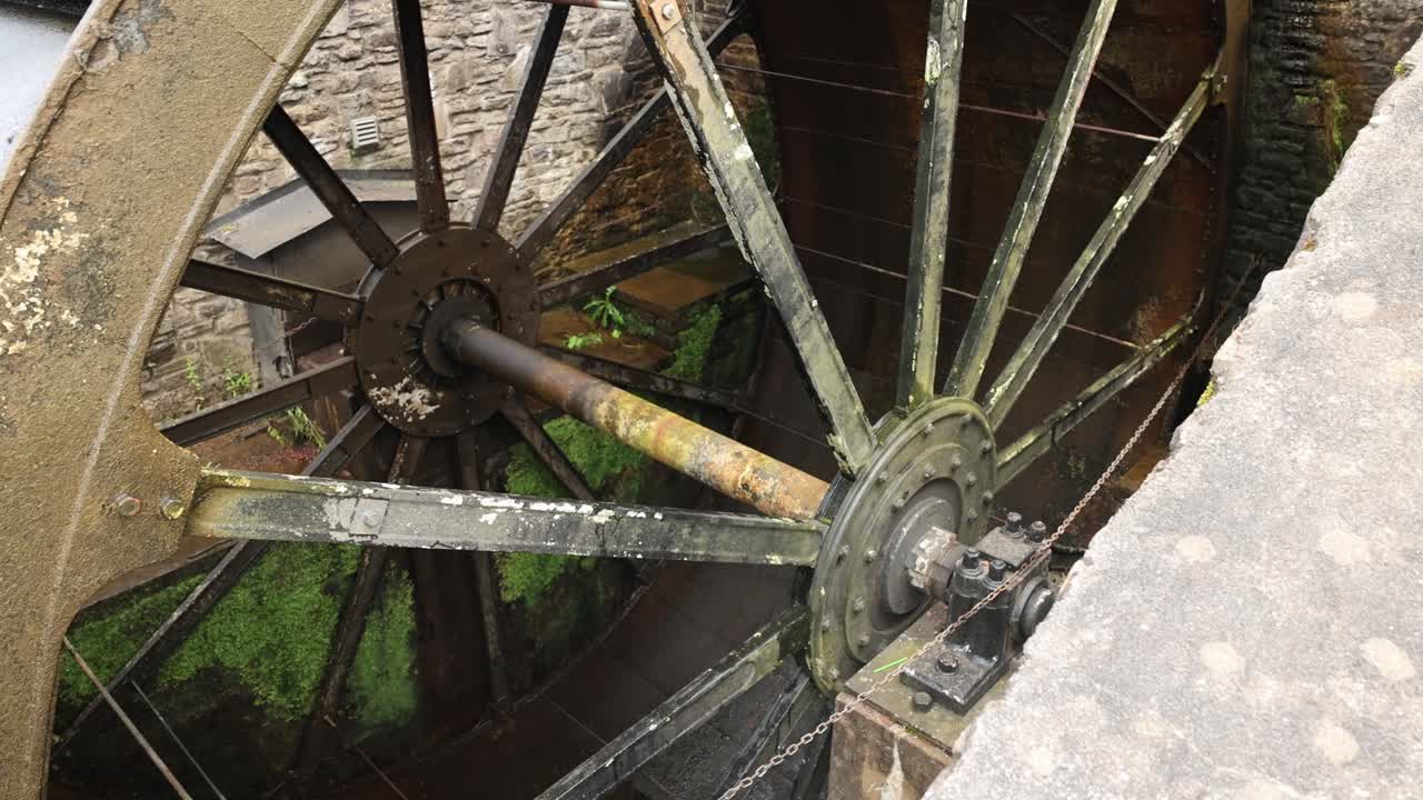 Close-up shot of a large metal metal wheel spinning to generate electricity
