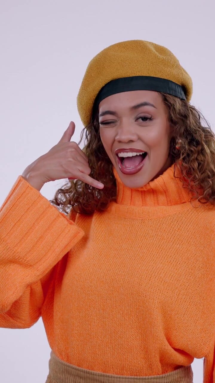 Young Woman Making Call Me Gesture and Winking at Camera