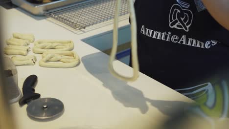 persona torciendo y formando masa cruda en pretzels - ángulo alto, cámara lenta