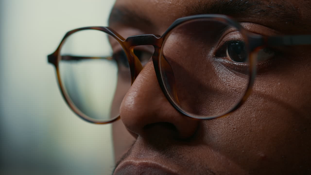 Closeup portrait of african american database developer with glasses working focused looking at computer screen