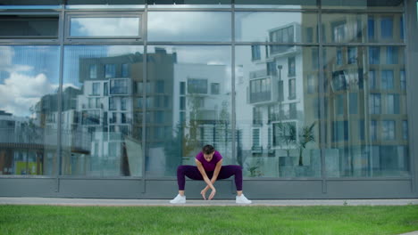 woman doing yoga outdoors in a city