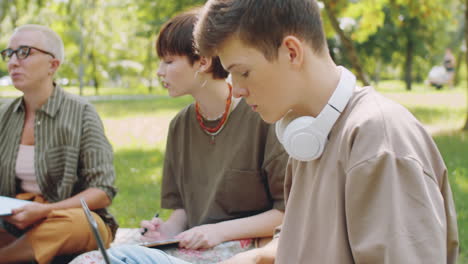 Estudiante-Escribiendo-En-La-Computadora-Portátil-En-La-Lección-Al-Aire-Libre-En-El-Parque