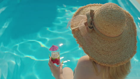 woman enjoying a cocktail by the pool