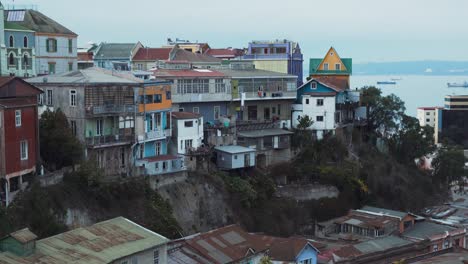 jib up of picturesque colorful hillside houses in cerro alegre, sea in background on an overcast day, valparaiso, chile