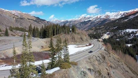 car around mountain curve 4k drone