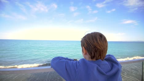 young boy looking out over ocean