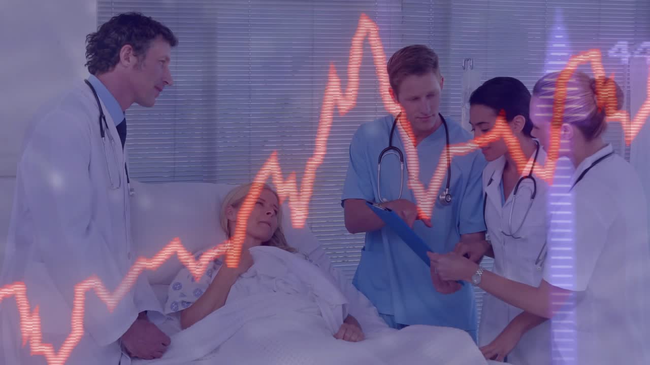 Patient raising hand talking as team adjusting IV reviewing chart with vitals graph planning care