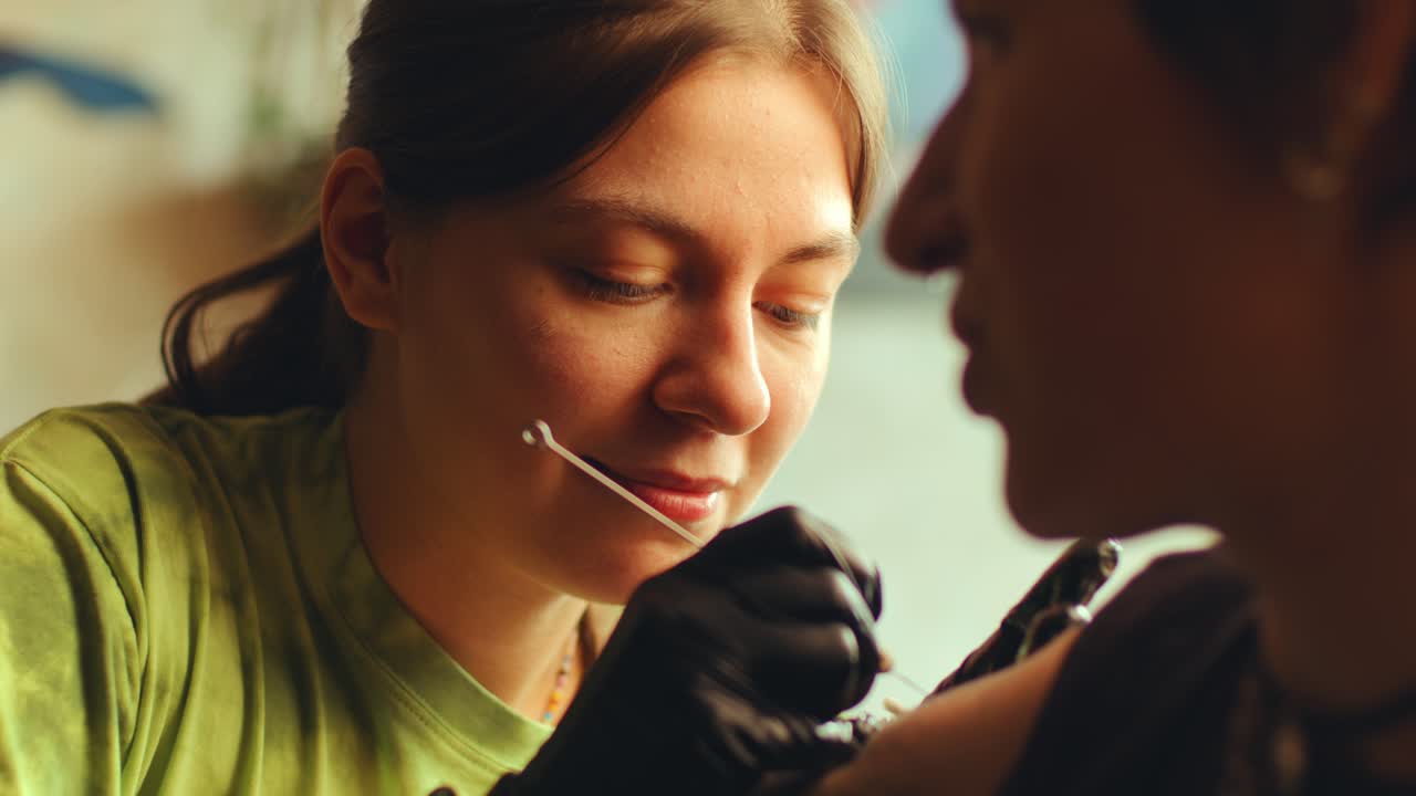 Tattoo Artist Doing Hand-Poked Tattoo for Female Client in Salon