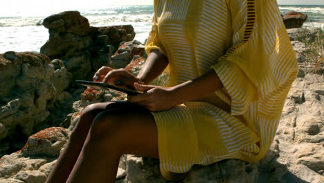 Mid-section-of-woman-using-digital-tablet-on-the-beach-4k