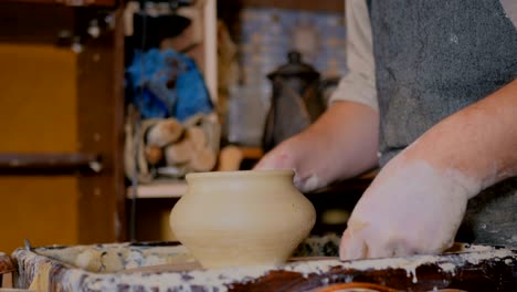 professional male potter working in workshop, studio