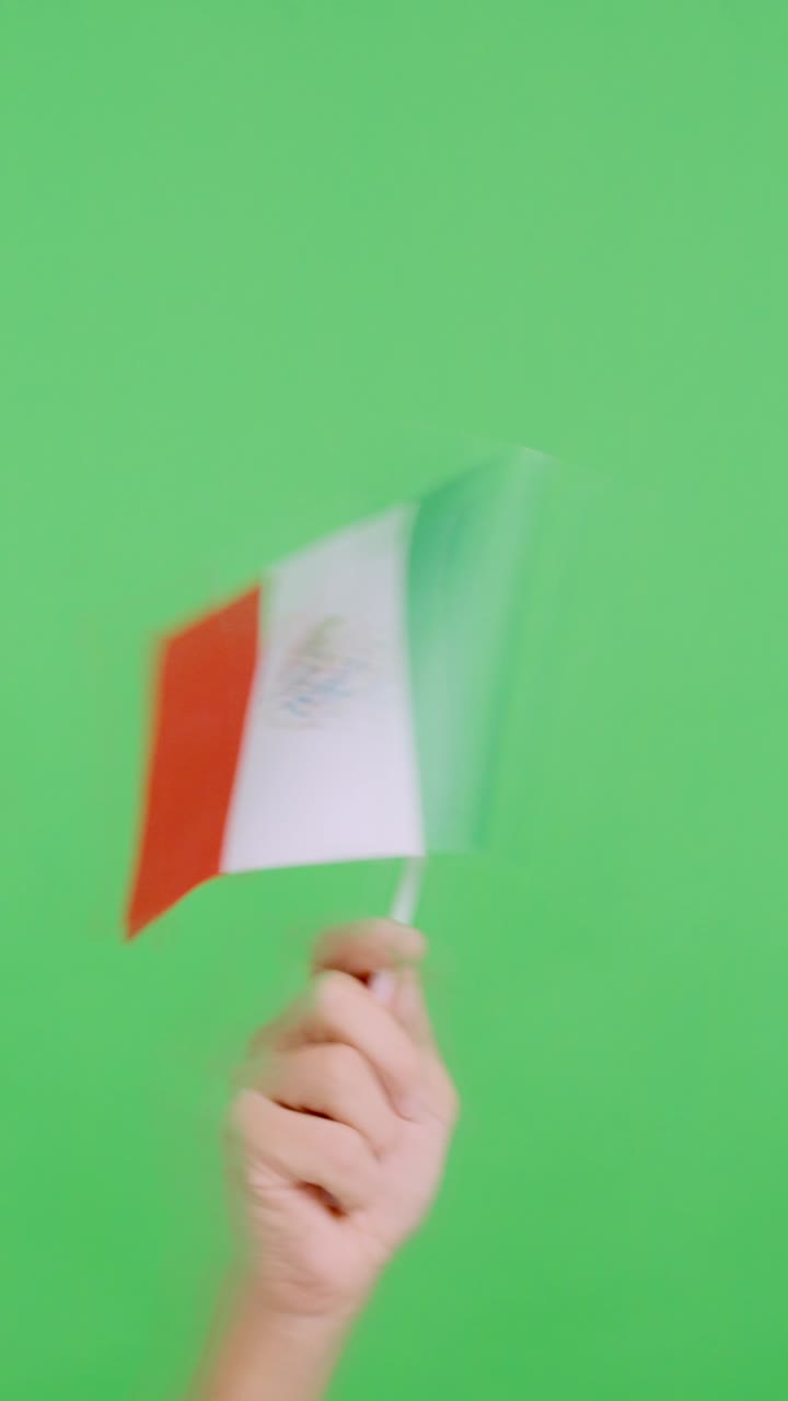Mano che agita un gagliardetto con la bandiera nazionale messicana