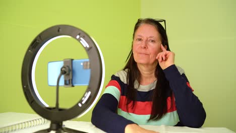 Elderly-Woman-Having-Portrait-Shoot-Using-Her-Smartphone-And-Ring-Lamp---medium-shot