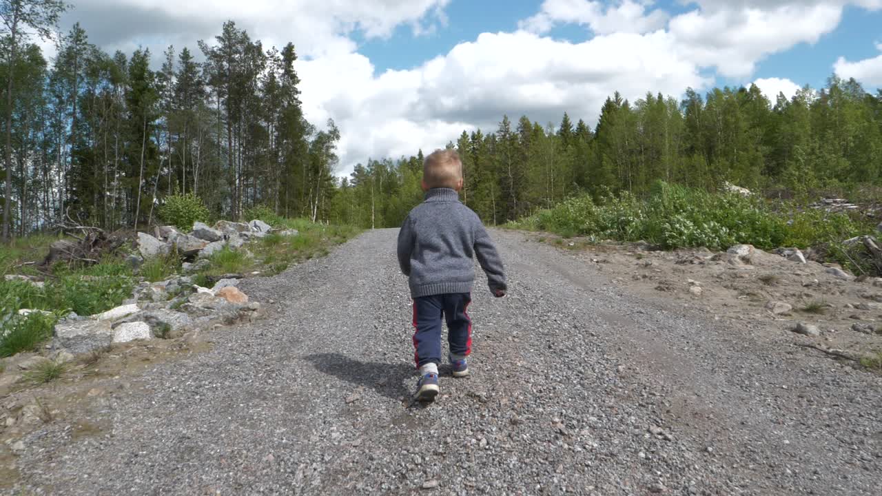 시골 길을 달리는 어린 소년을 따라 슬로우 모션 오르막 투쟁