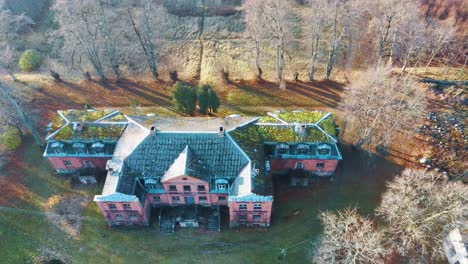 old red brick house, katvari manor in latvia and katvaru lake in the background