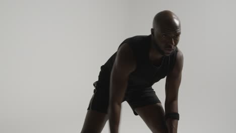 studio action shot of male basketball player dribbling ball against white background