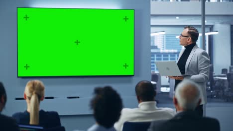 modern product presentation event: caucasian businessman speaks, uses green chroma key screen wall tv. press conference for group of diverse investors, digital entrepreneurs, businesspeople applaud