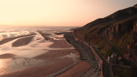 impresionante puesta de sol rosa sobre grandes acantilados de piedra caliza, llandudno, gales