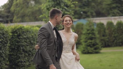 Encantadores-Recién-Casados-Novia-Caucásica-Novio-Caminando-En-El-Parque,-Tomados-De-La-Mano,-Pareja-De-Novios-Familia