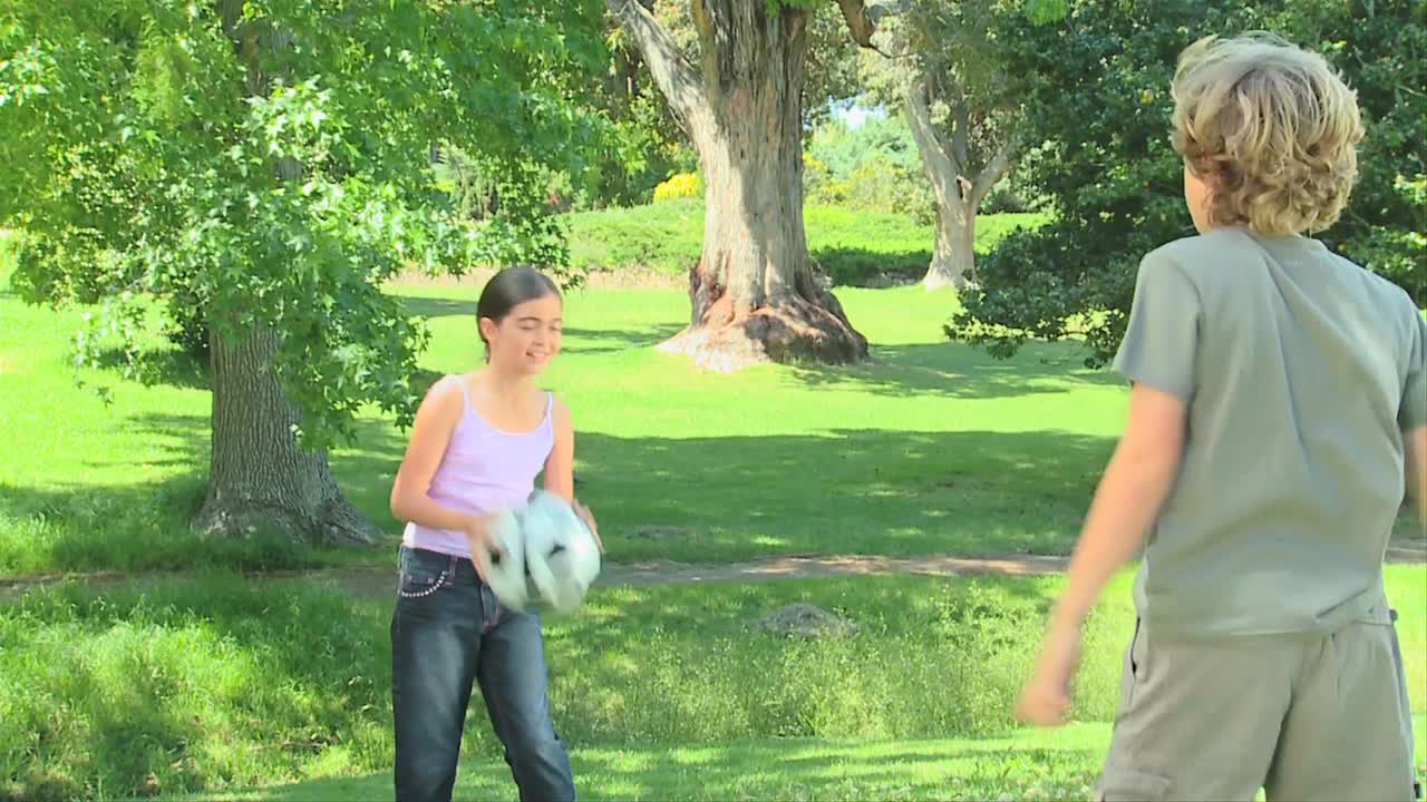 어린 소년과 그의 여동생이 공으로 놀고 있다