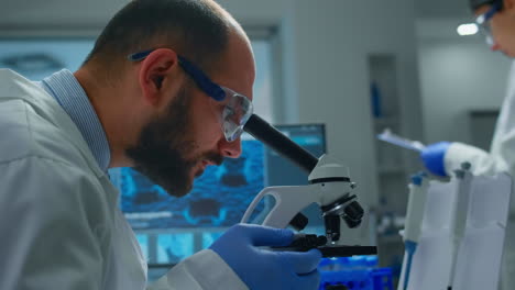 hombre científico de investigación mirando muestras bajo el microscopio