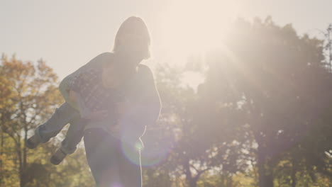 happy mom playing with baby in the sun