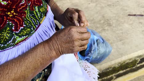 mexican craftswoman sitting knitting in michoacan
