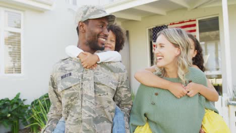 Video-of-happy-diverse-family-standing-outside-of-house