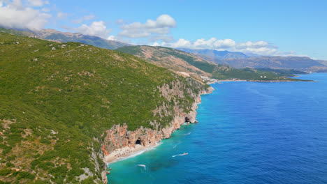 Aerial-drone-forward-moving-shot-deep-blue-sea-along-the-Gjipe-Beach-in-Albania-on-a-sunny-day